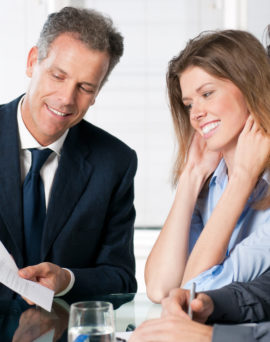 Happy young couple discussing with a financial agent their new investment